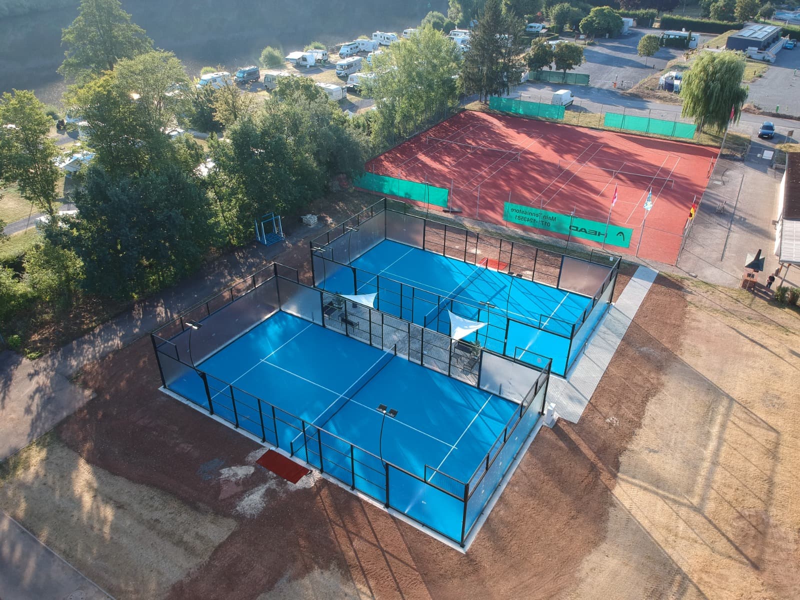 Die zwei Padelcourts mit Glaswänden aus der Vogelperspektive, direkt daneben der Tennisplatz des TV Zellingen