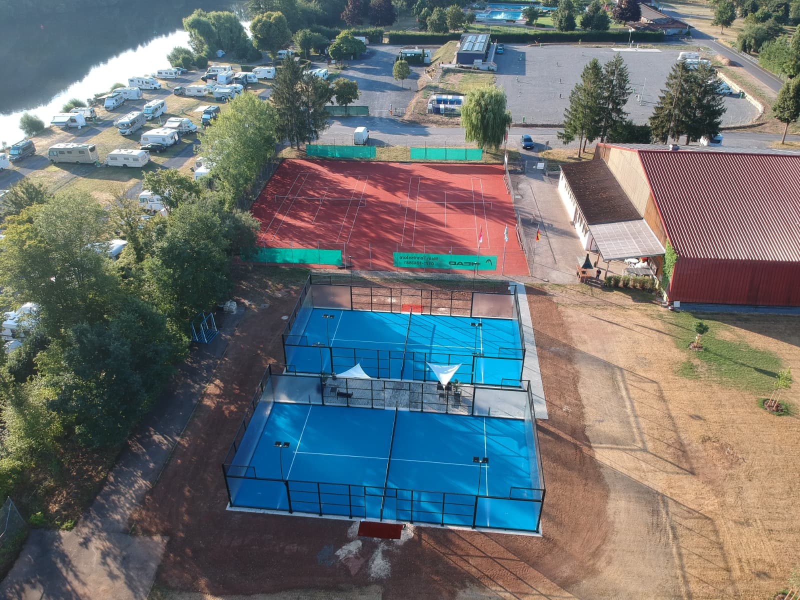 Luftbild des Sportgeländes an der Badstraße mit Padelcourts, Tennisplatz und dem Main im Hintergrund