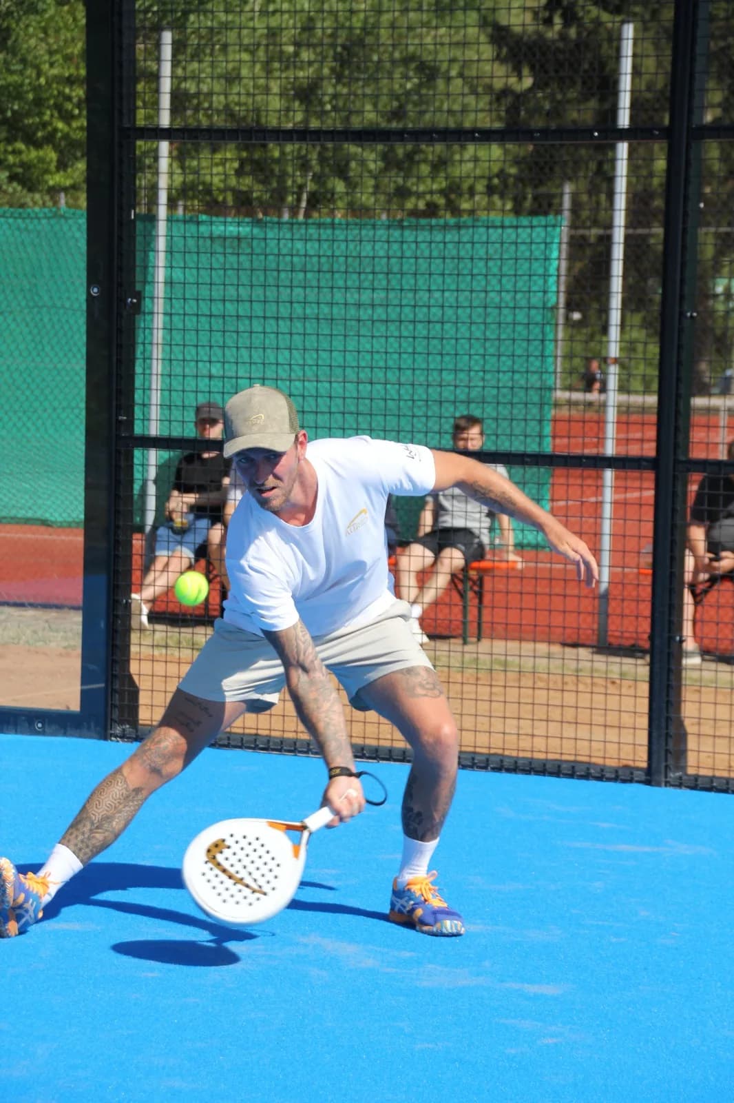 Padel-Profi holt einen tiefen Ball am Netz